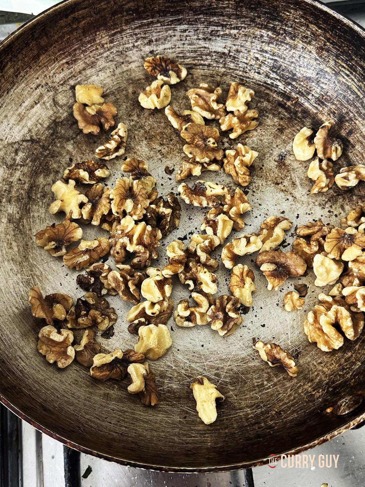 Roasting the walnuts in a pan over a medium heat.