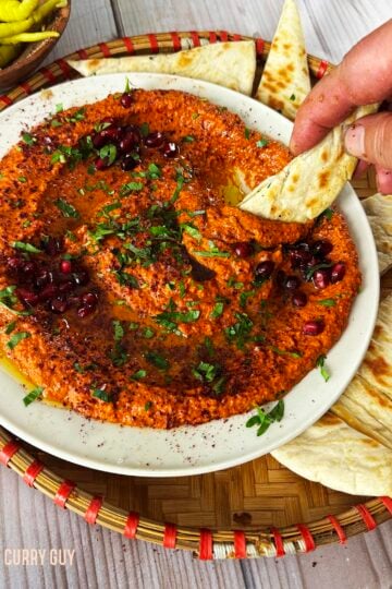 Dipping a pita into the muhammara.