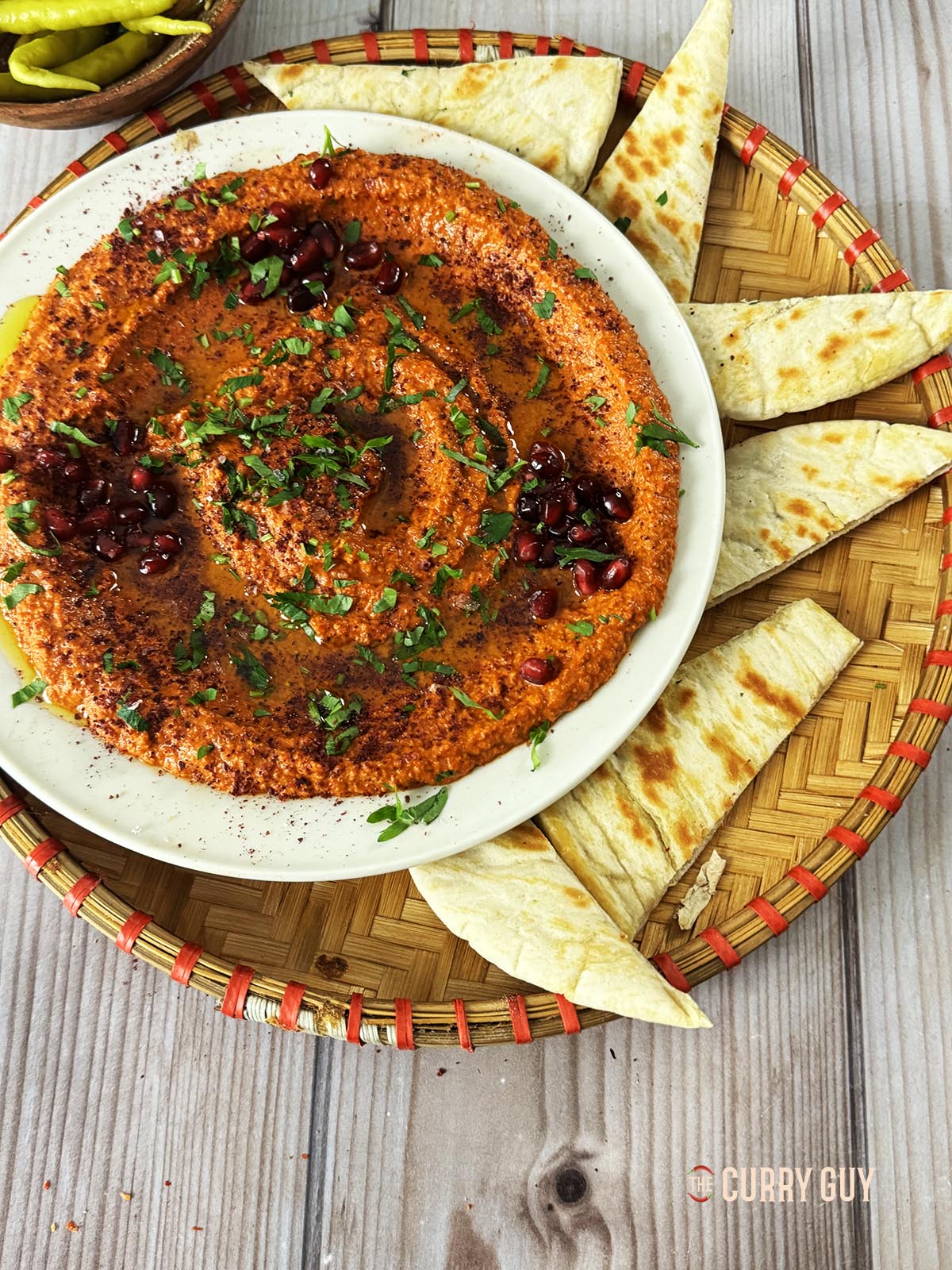 Muhammara in a serving dish with pita breads. 