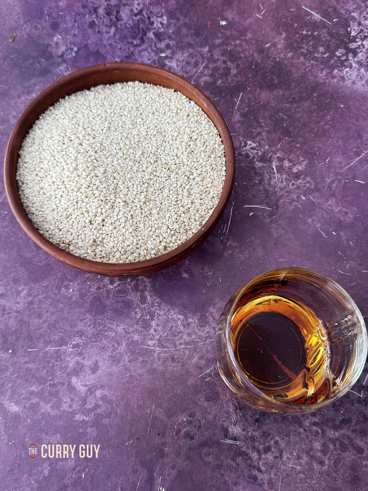Ingredients for the recipe. Sesame seeds and sesame oil on a work surface.