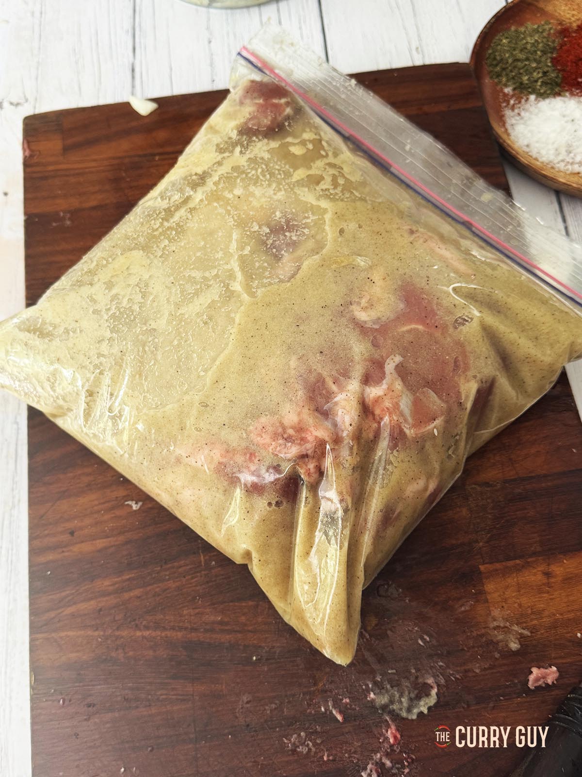 Marinating the lamb in the onion marinade in a large plastic freezer bag.