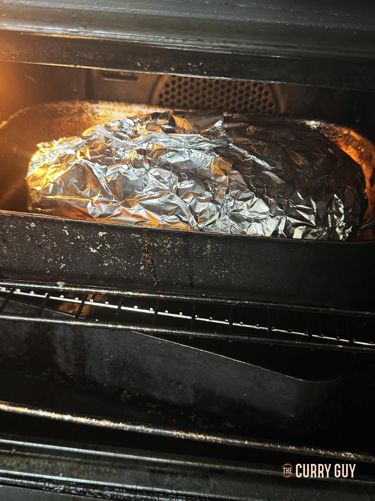 Placing the lamb in the oven to slowly roast.