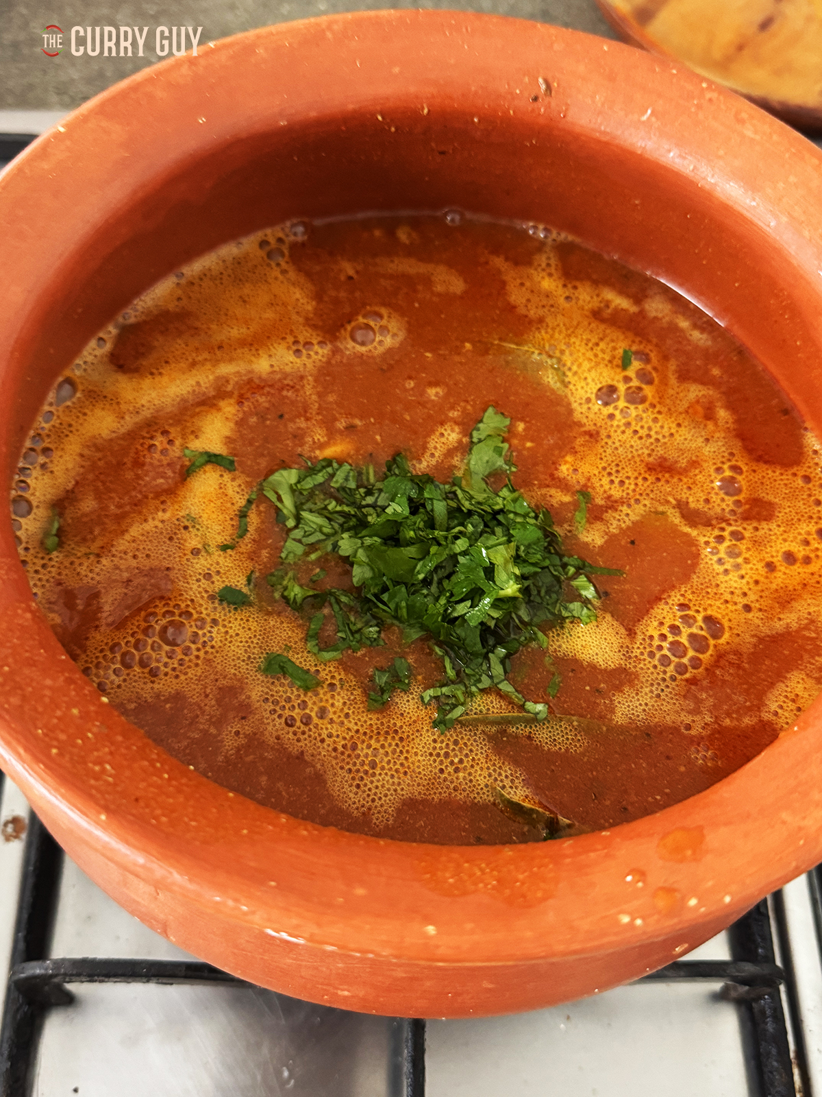 Adding the chopped coriander (cilantro) to the tomato shorba before serving.