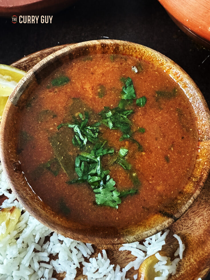 Tomato shorba in a soup bowl, garnished with chopped coriander (cilantro).