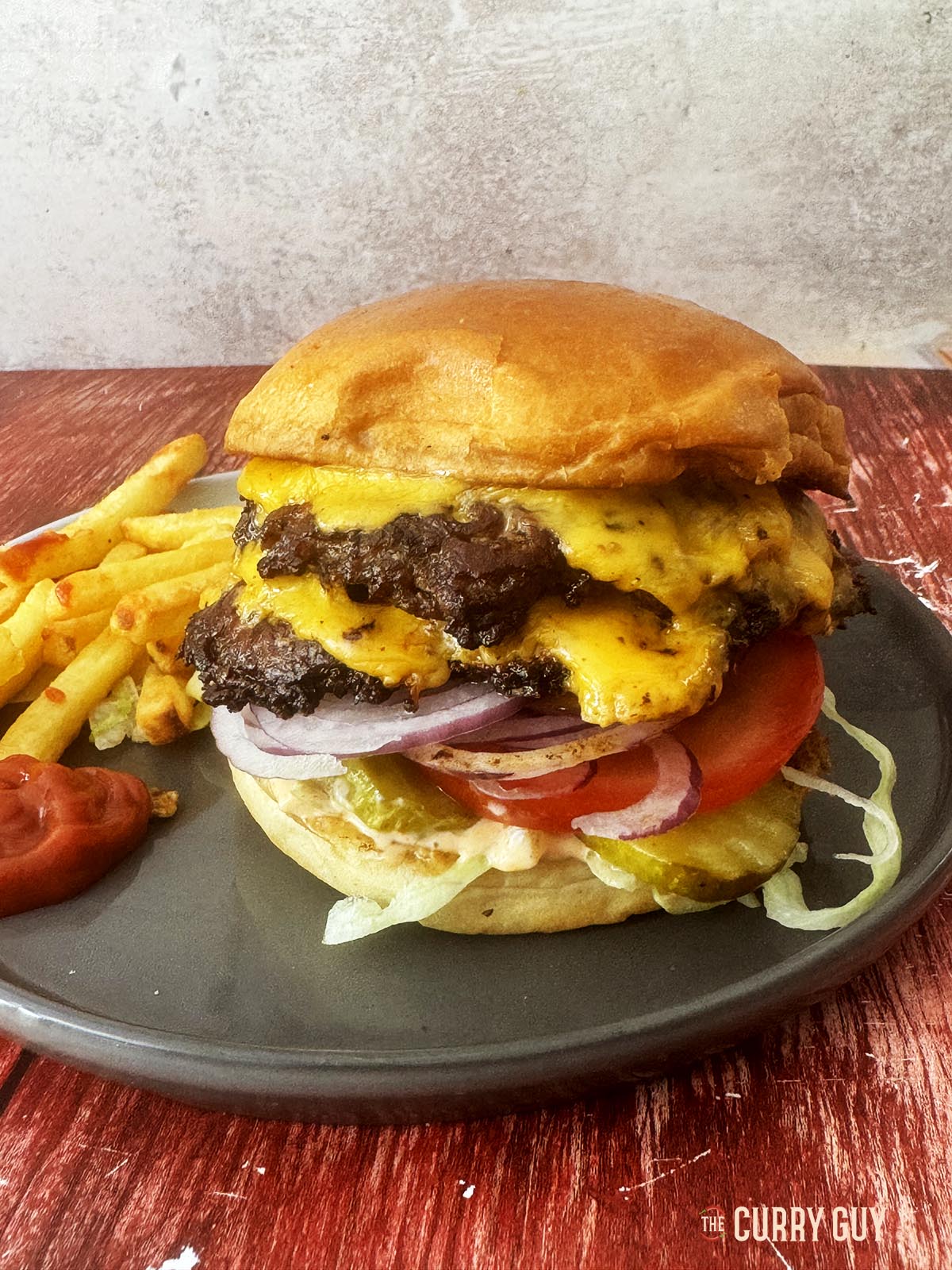 Smash Burger on a serving plate with fries.