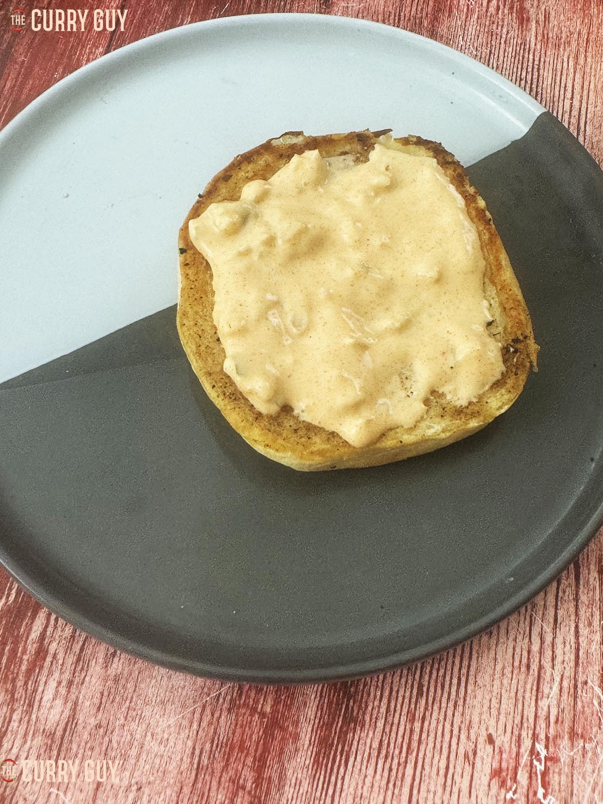 The bottom bun slathered with burger sauce.