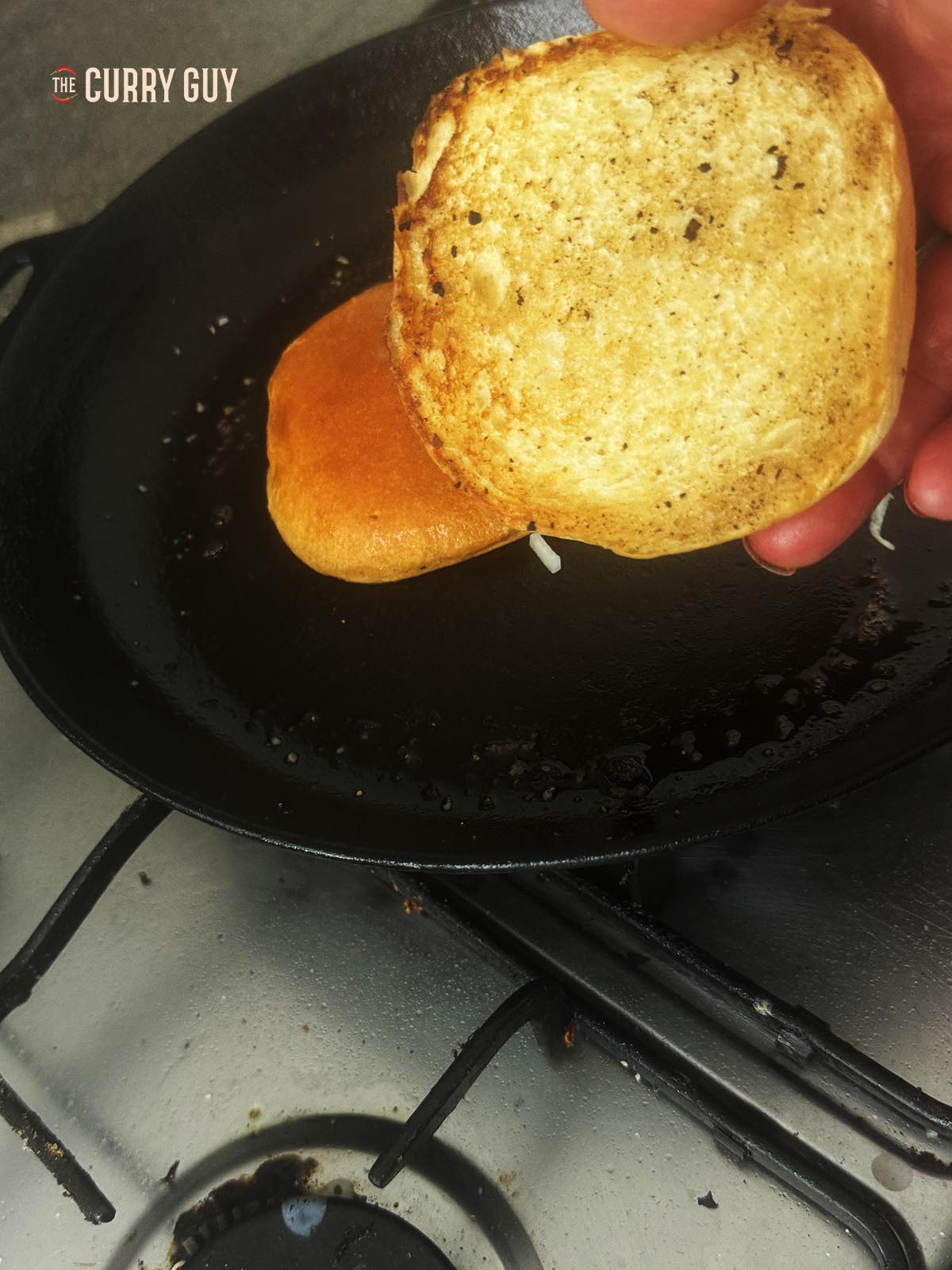 Toasting the buns in butter in a hot pan.