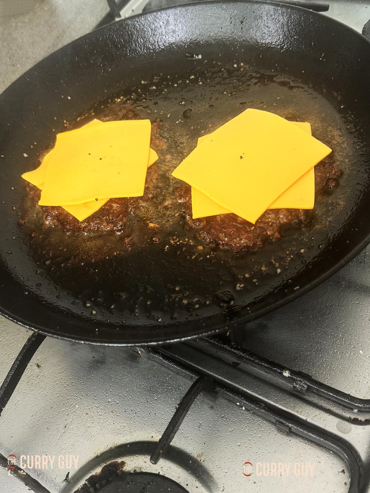 Seasoning the burger patties with salt and pepper and topping with American style cheese.