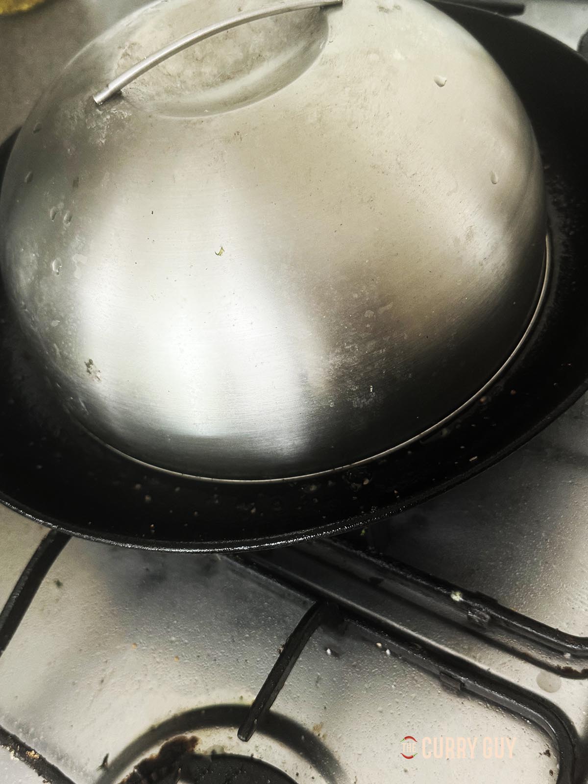 Placing a burger dome on top of the burger patties.