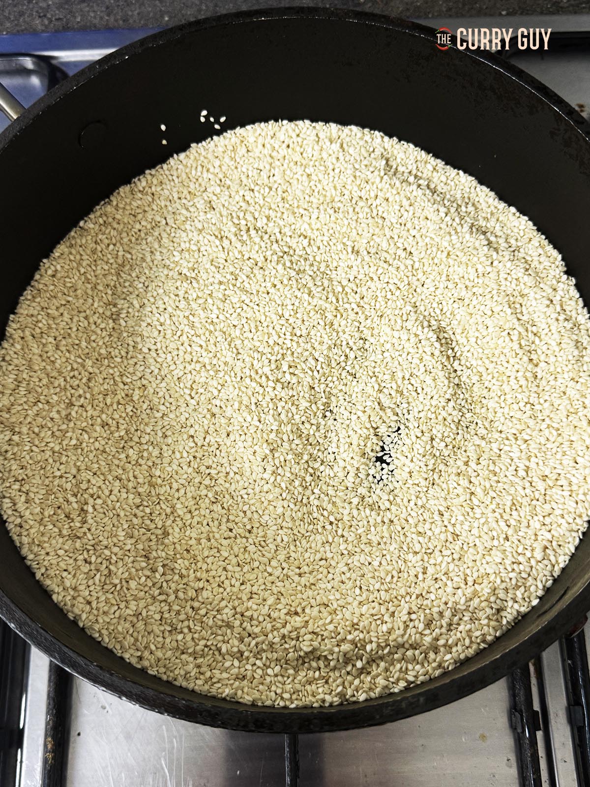 The raw sesame seeds in a frying pan ready to roast.