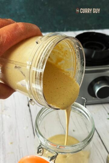 tahini sauce being poured into a jar.