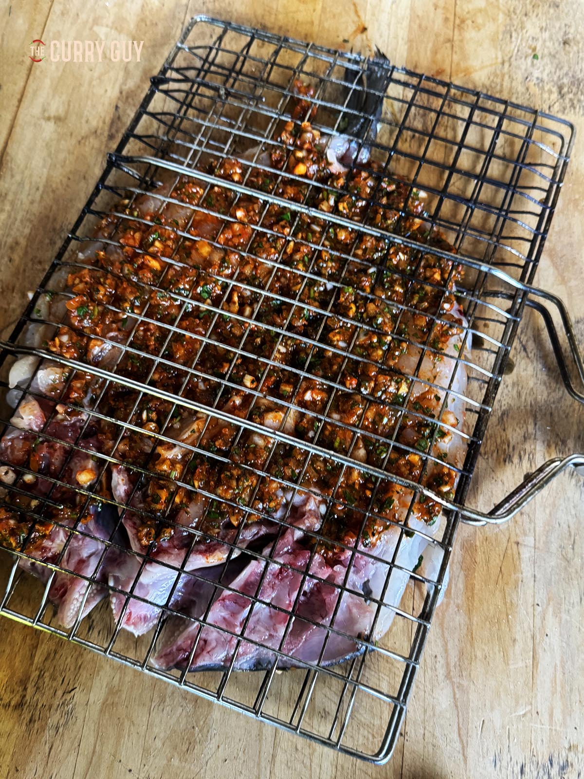 Placing the fish in a fish basket for grilling.