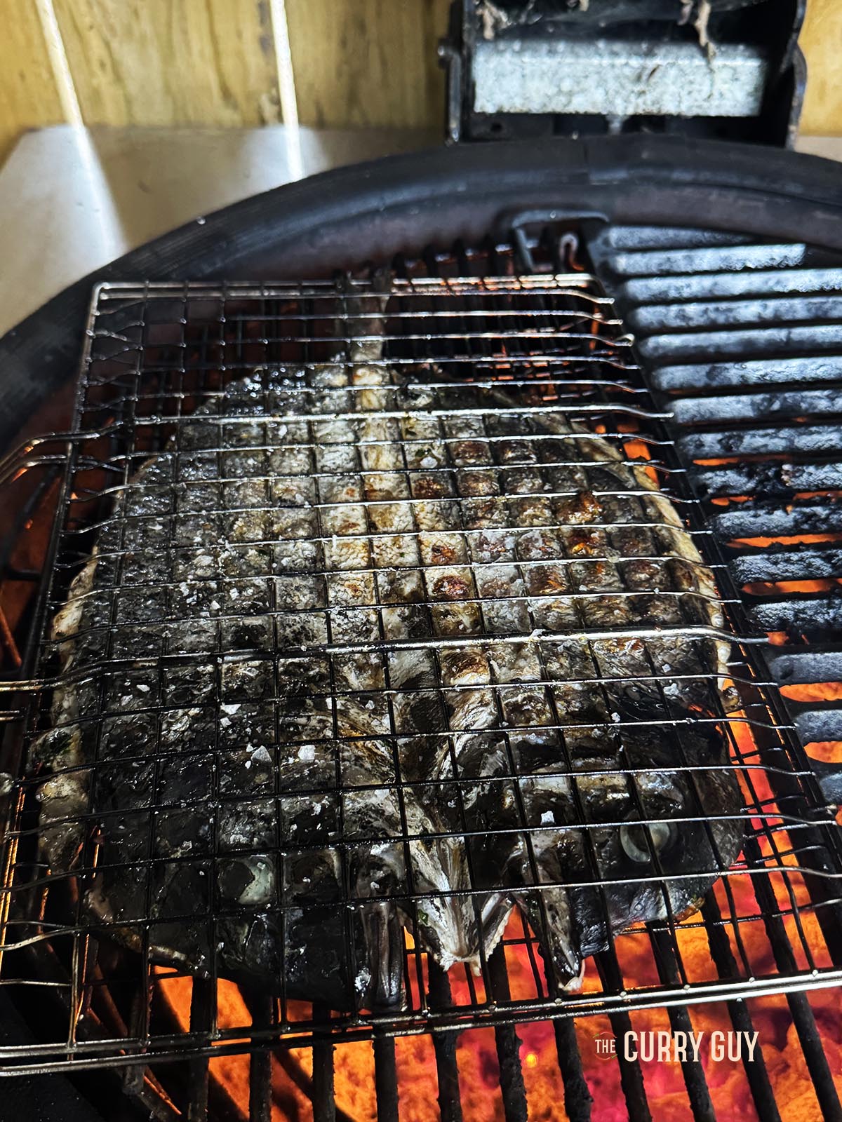 The fish on the barbecue showing the crispy skin of the fish.