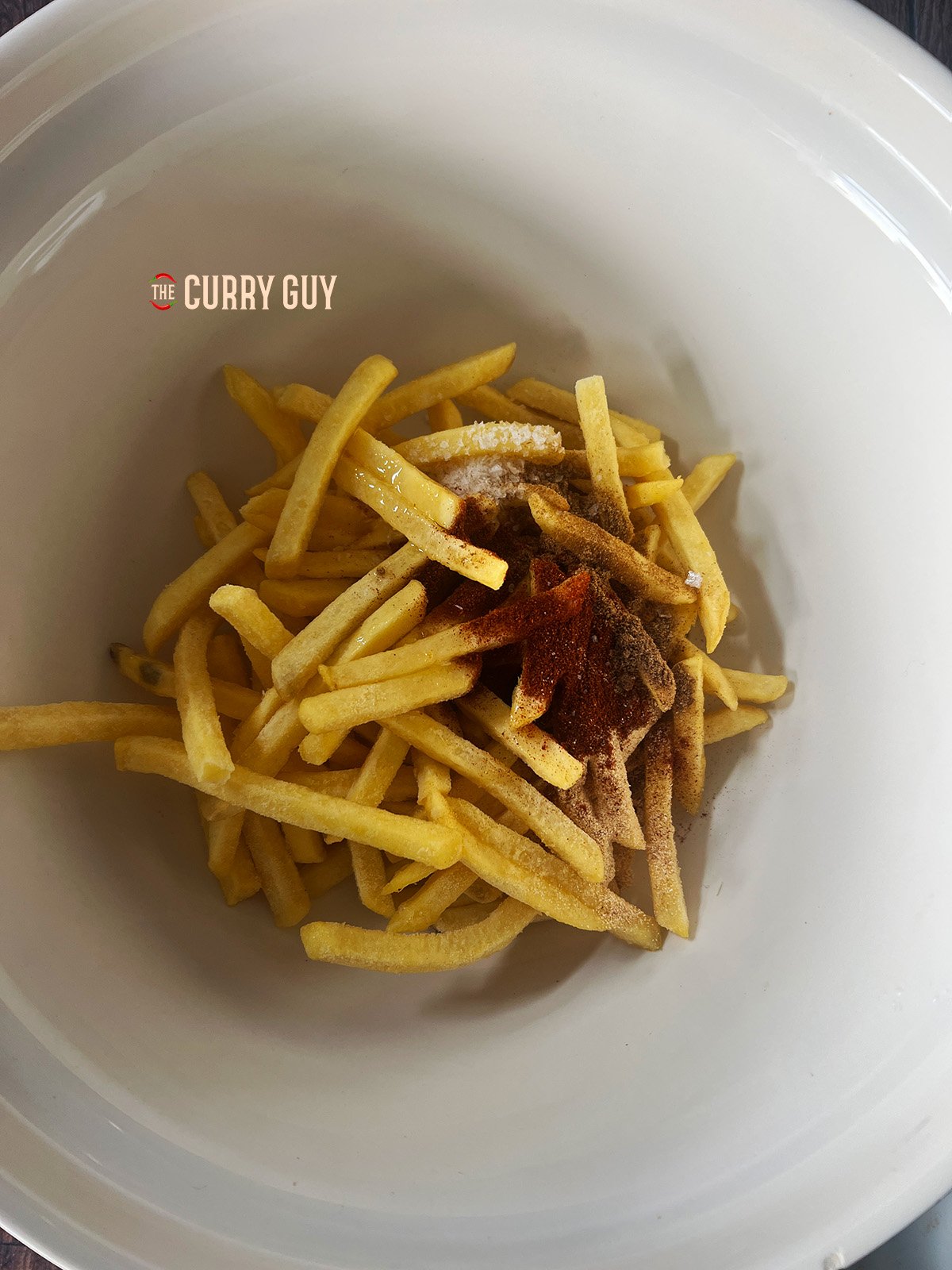 Spices being added to the bowl. 