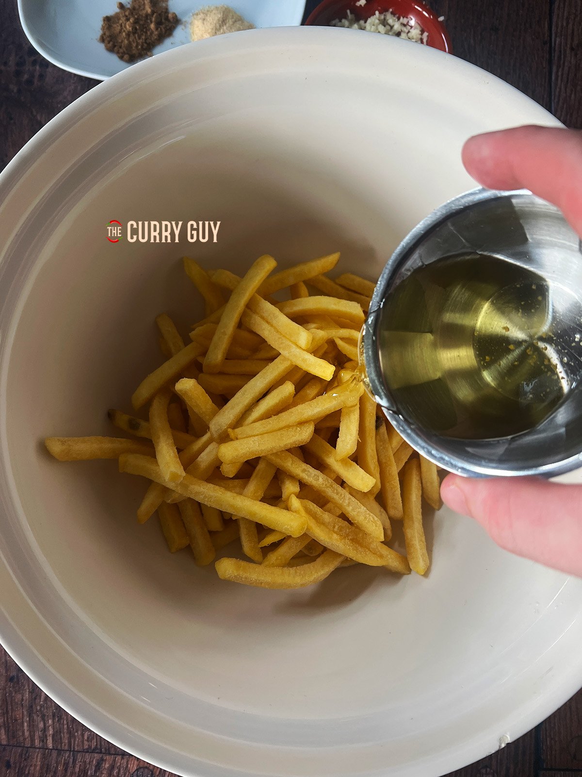 Frozen chips in a bowl with added oil. This is the first step of the recipe