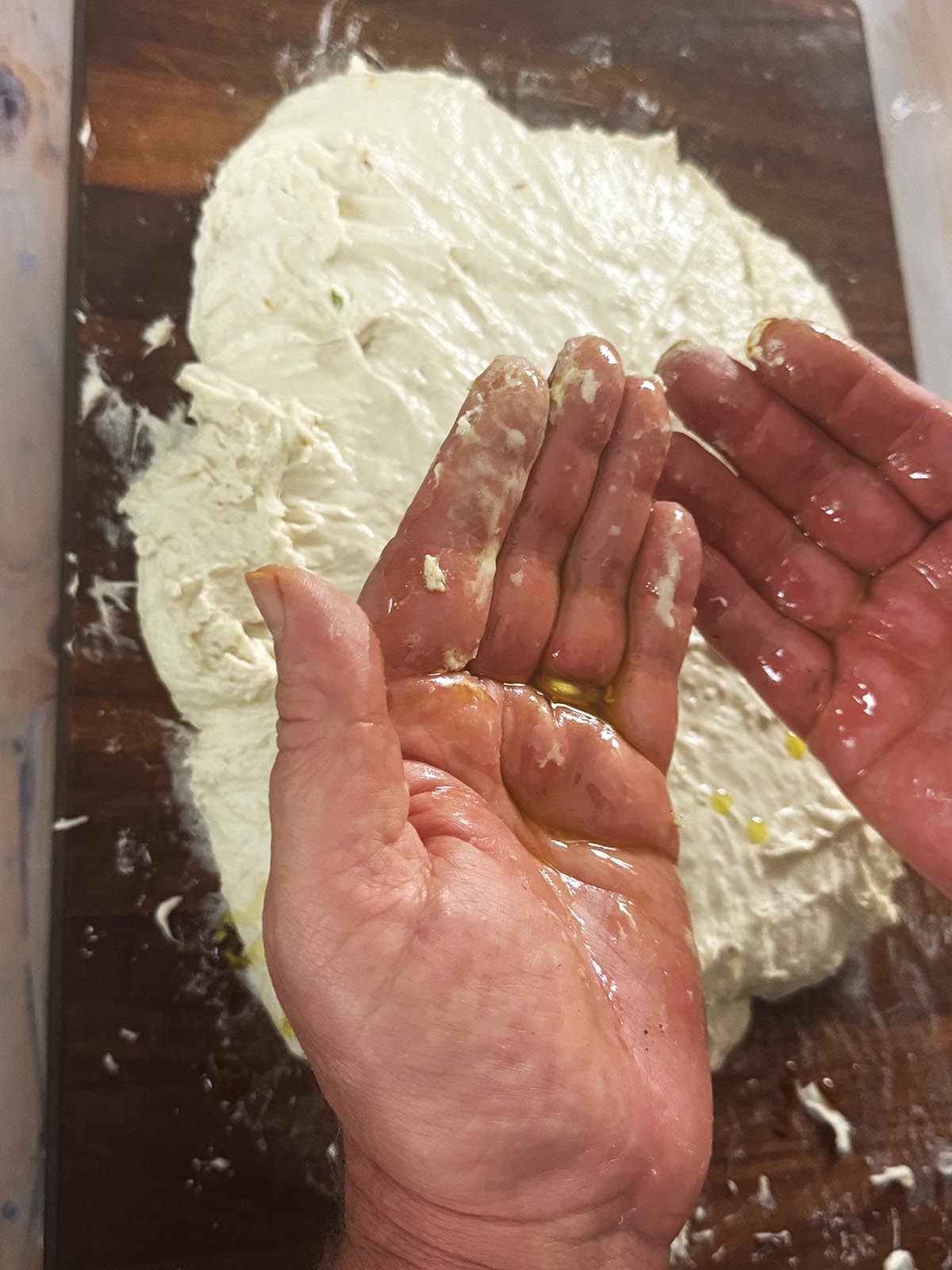 Oiling hands to knead the dough.