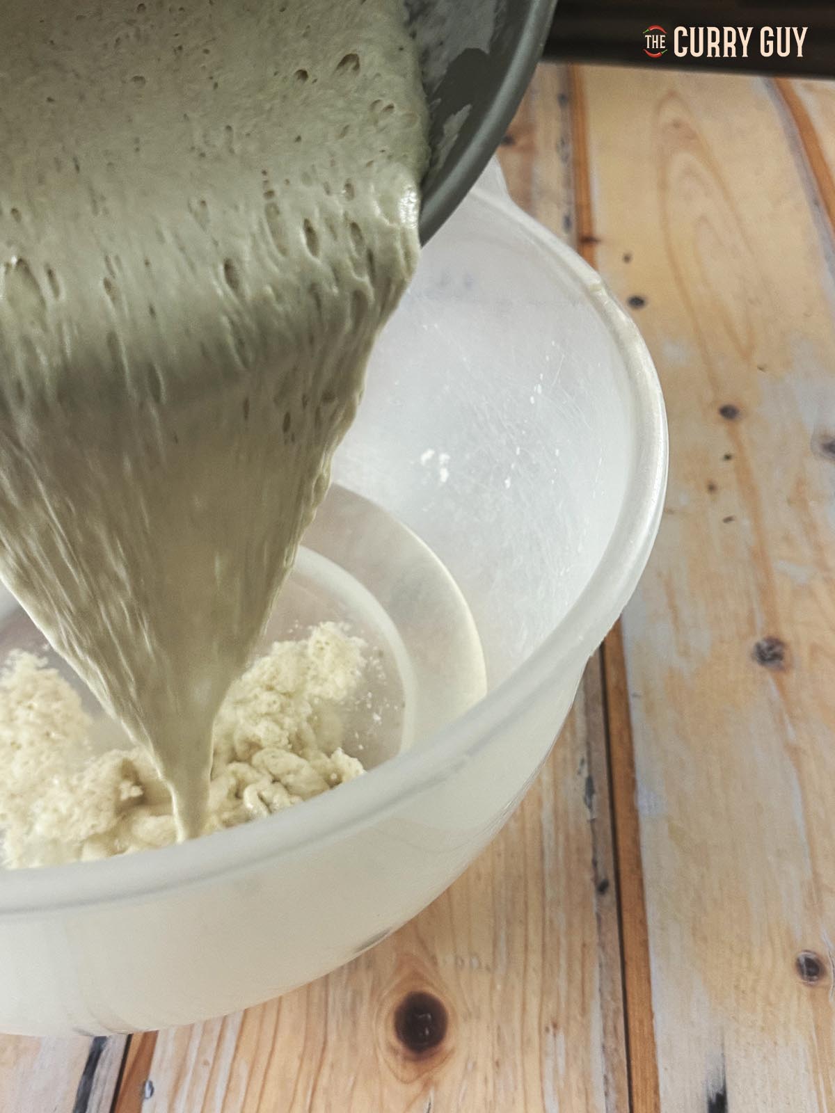 Pouring the starter for the dough into a bowl of water.
