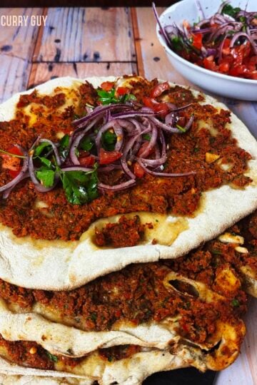 A stack of lahmacuns topped with Turkish Onion Salad.