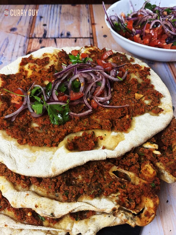 A stack of lahmacuns topped with Turkish Onion Salad.