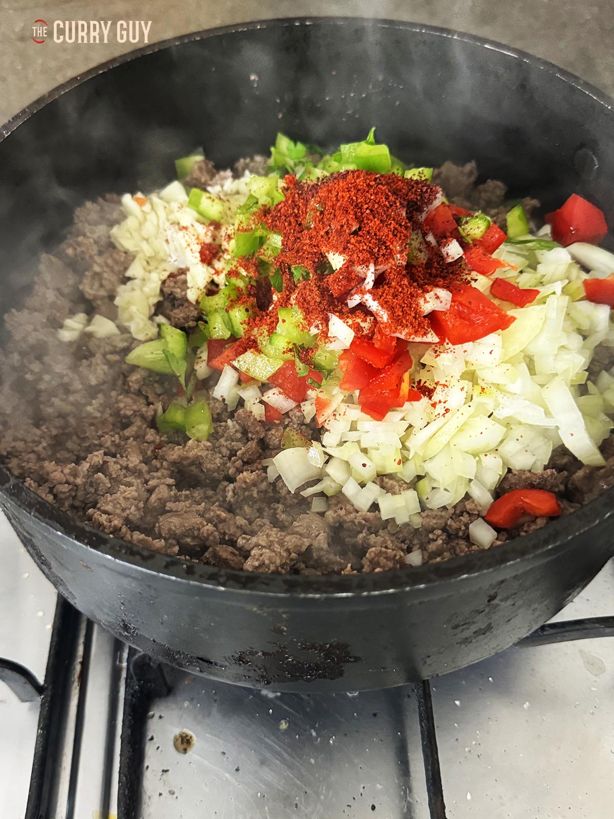 Stirring in the fresh chopped onion, bell peppers and garlic.