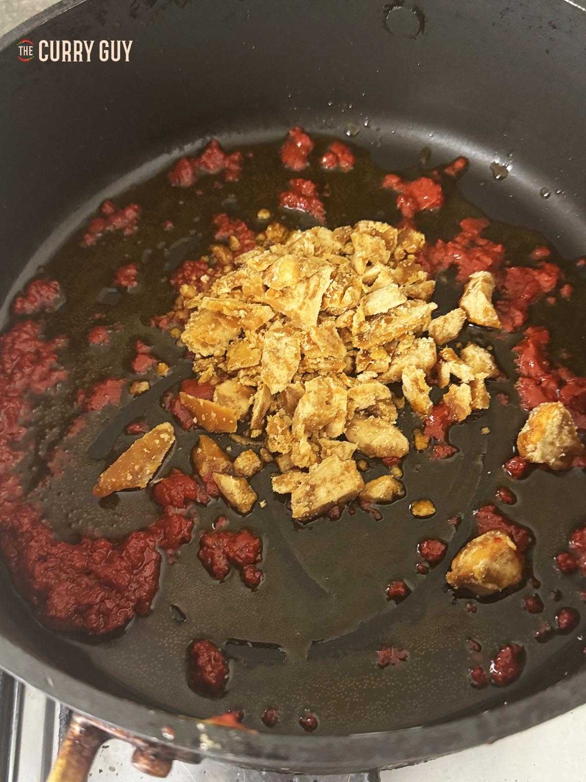 Adding jaggery to the pan to melt it.