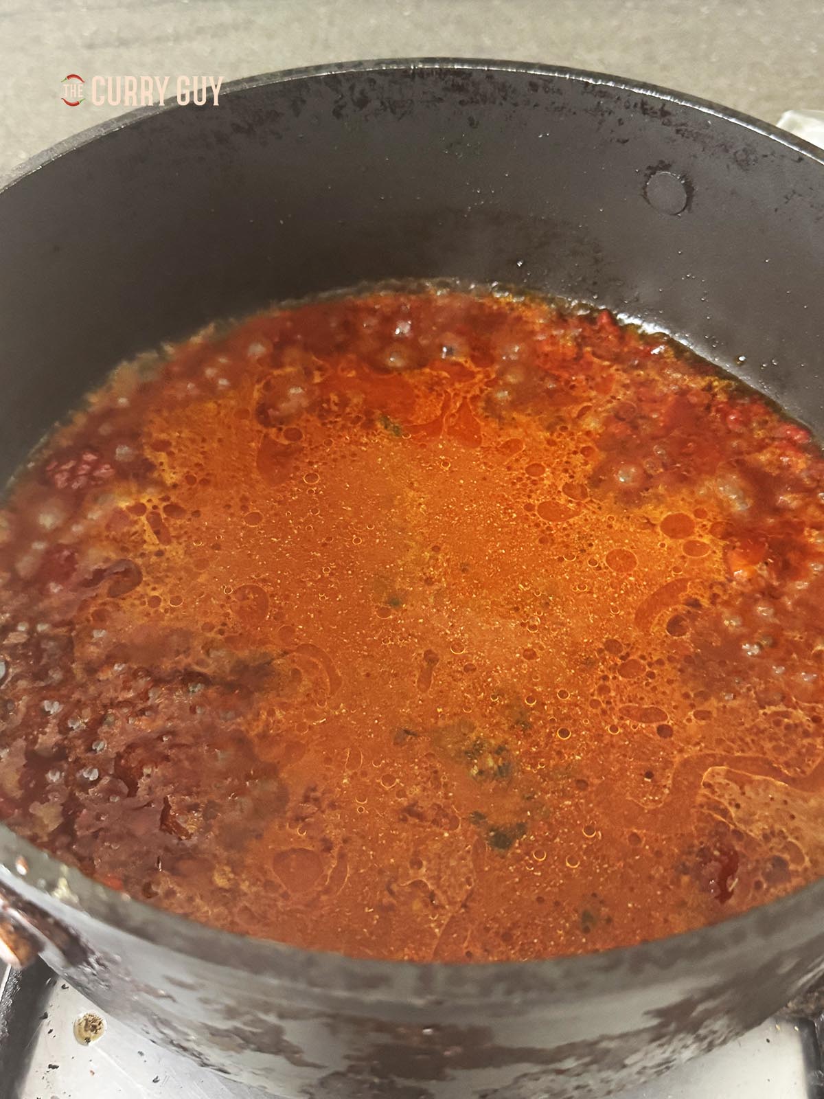 Adding the water, vinegar and spices to the pan.