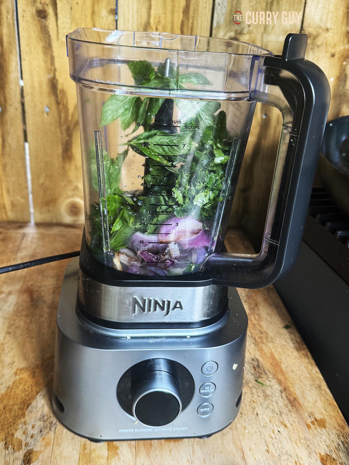 The water, lime juice, coriander (cilantro), mint leaves and the fried onion, chillies and garlic in a blender ready to blend.