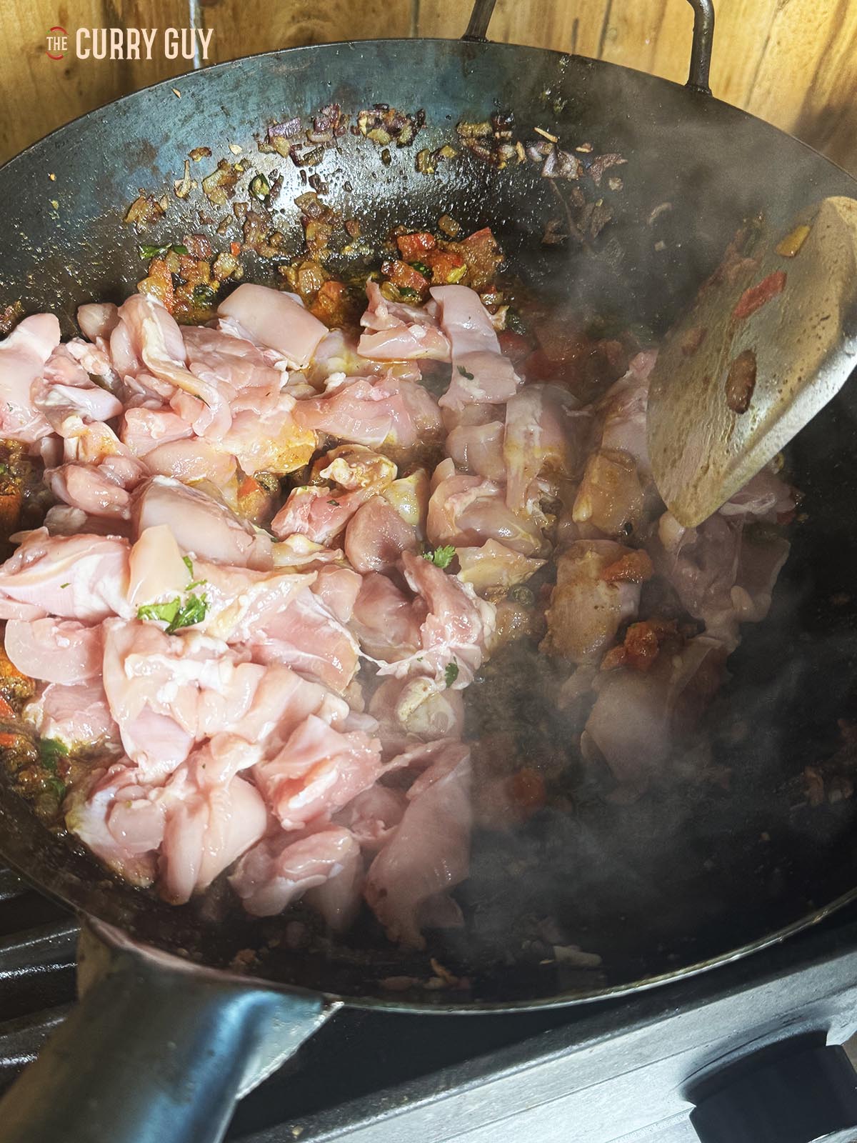 Adding the chicken to the pan.