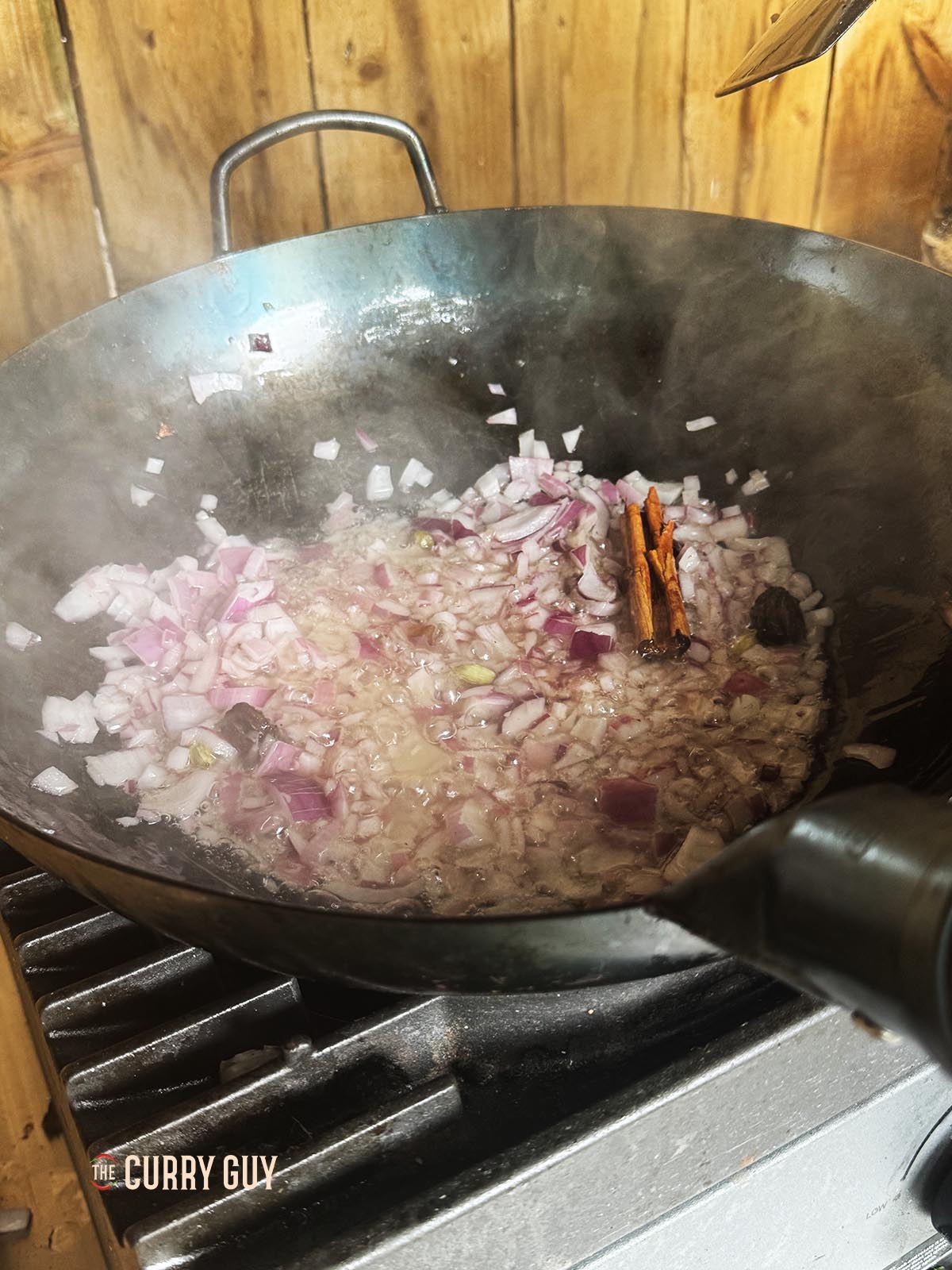 Frying the finely chopped onions in the pan with the spices.