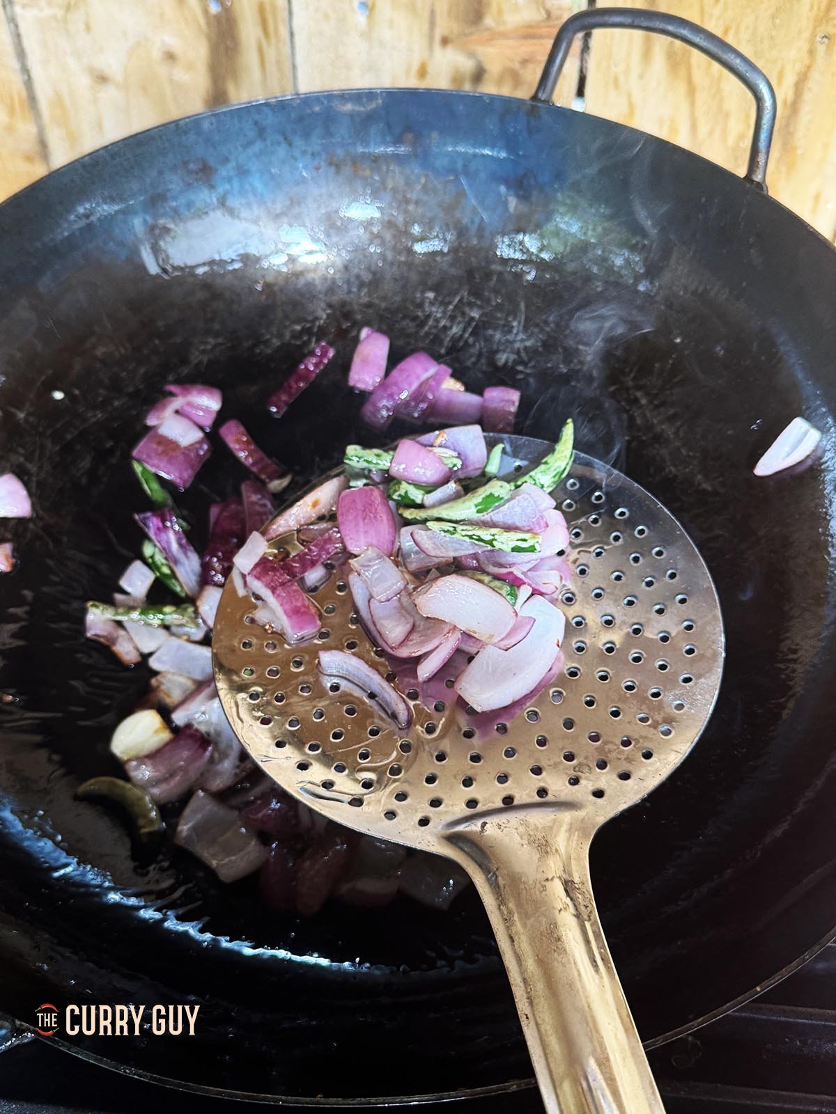 Transferring the fried onions, chilies and garlic to a blender.