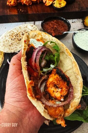 Turkish chicken kabob meat wrapped in a pita with salad and sauces.