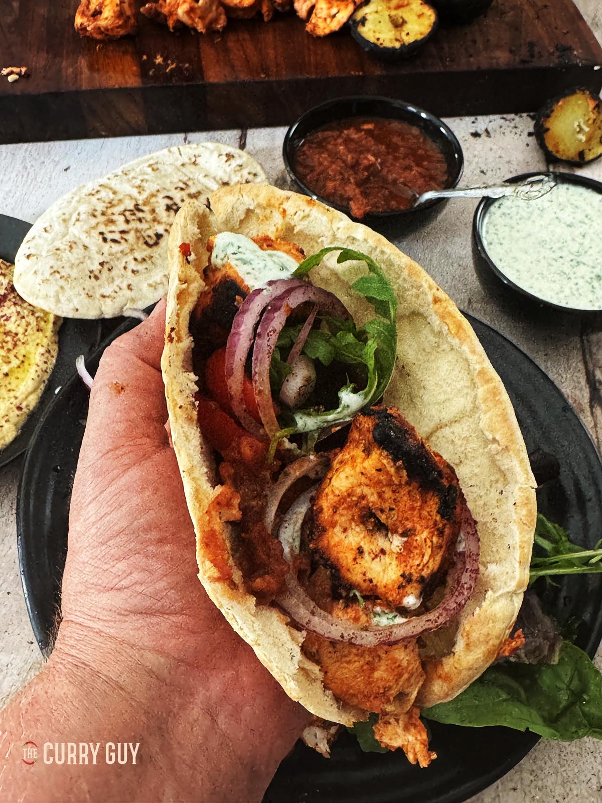 Turkish chicken kabob meat wrapped in a pita with salad and sauces.