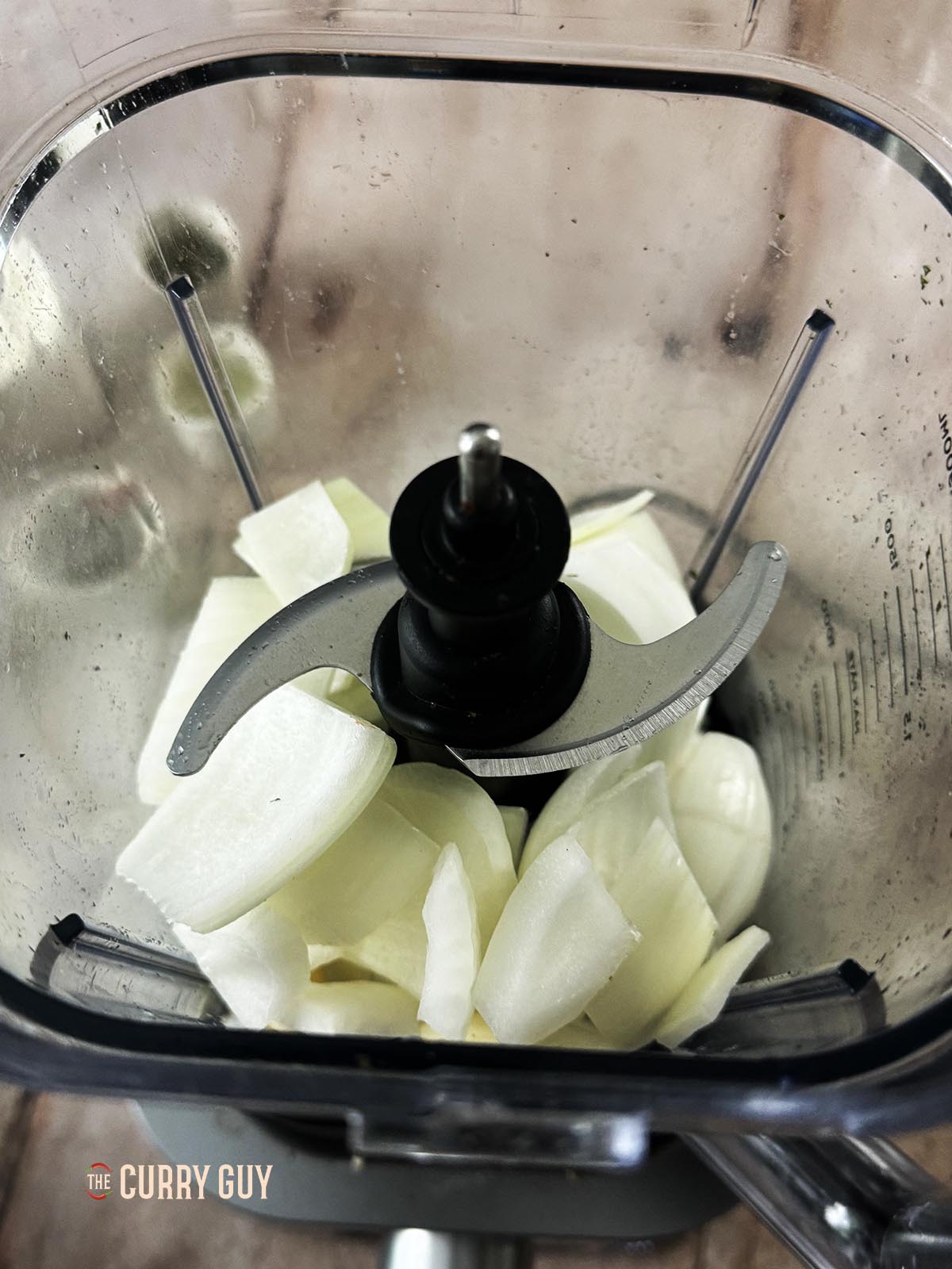 The onions and garlic in a blender ready to blend to a paste.