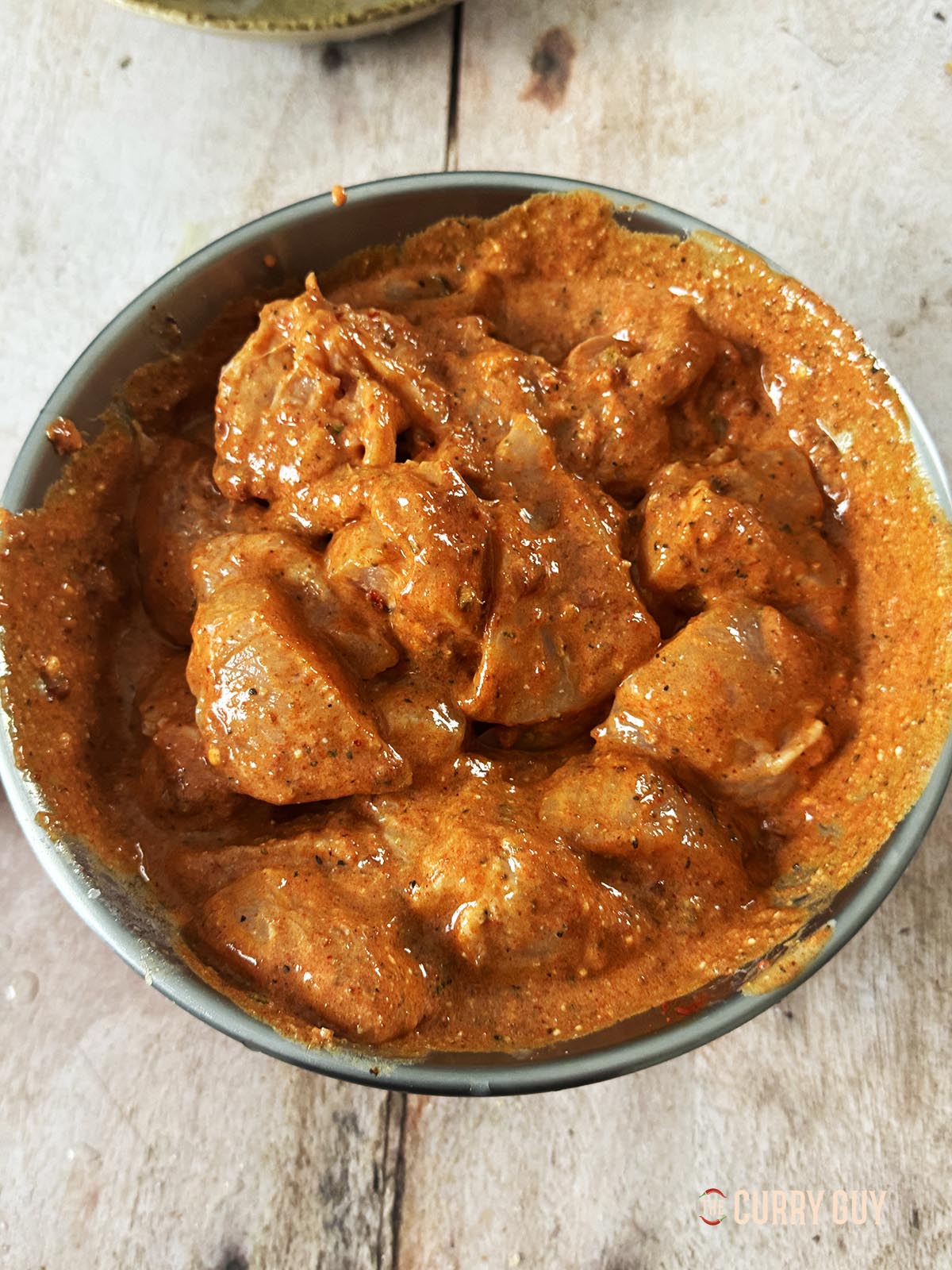 Marinating the chicken in the marinade in a mixing bowl.