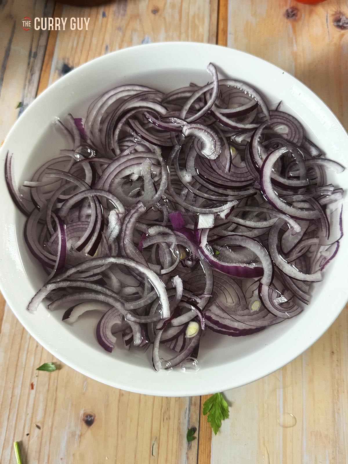 Soaking sliced red onions in water. 