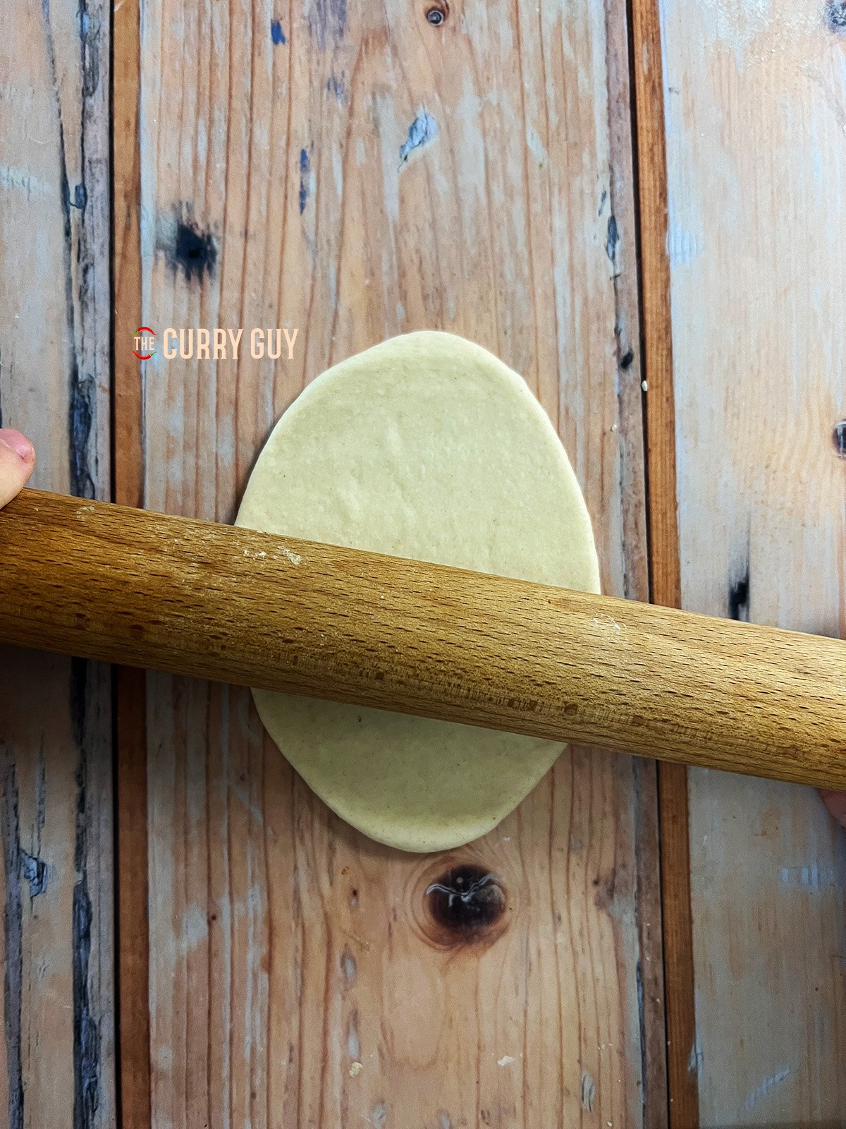rolling out the dough into a shape of a lotus leaf bao