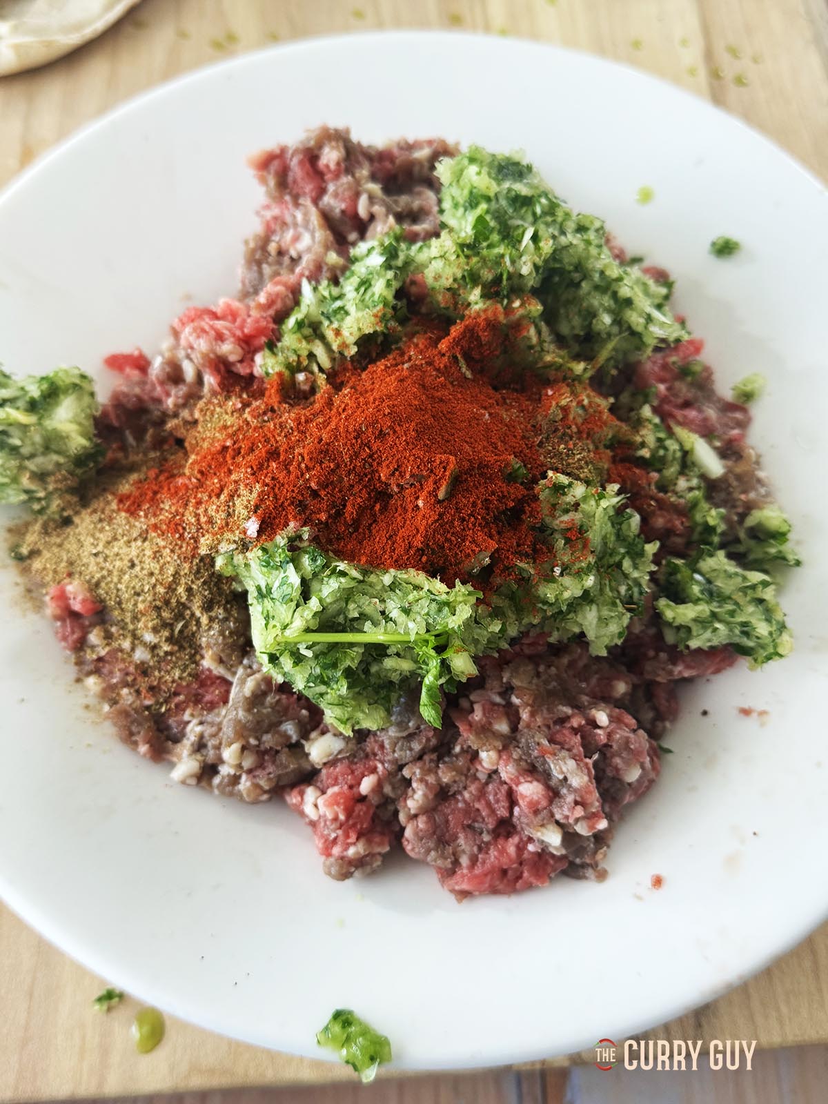 Adding the herb mixture and spices to the beef.