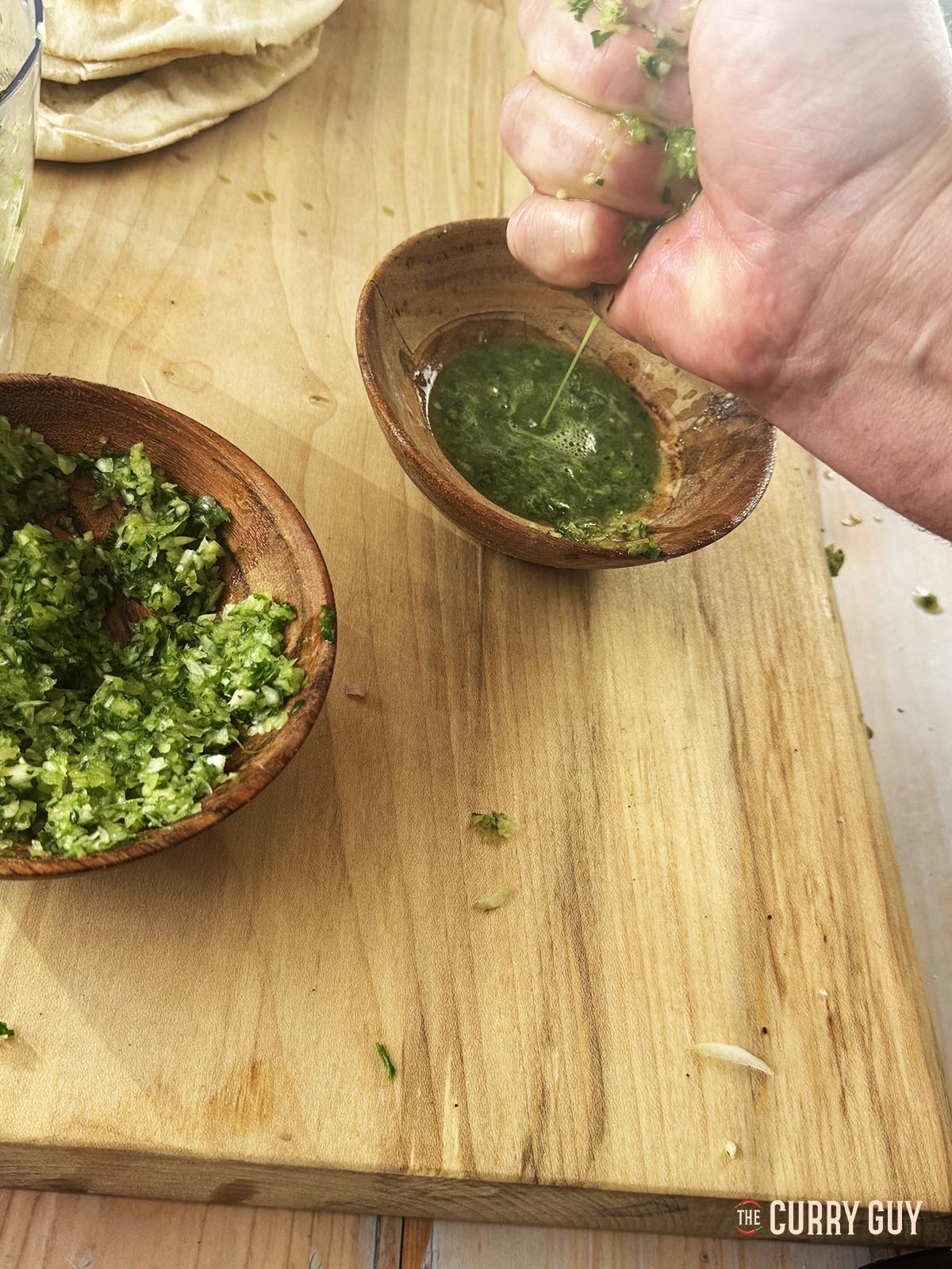 Squeezing the excess liquid from the onion, garlic and parsley mixture.