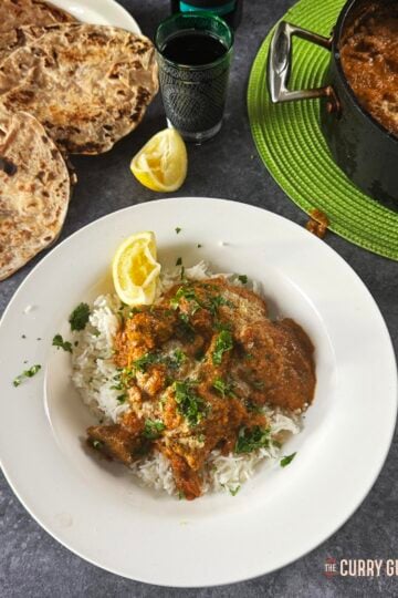 Beef tikka masala on a serving plate with chapattis on a side dish.
