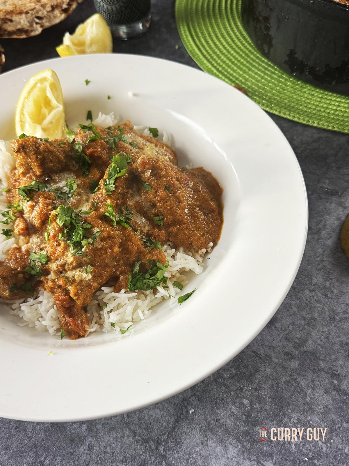 Beef tikka masala on a serving plate with a lemon wedge.