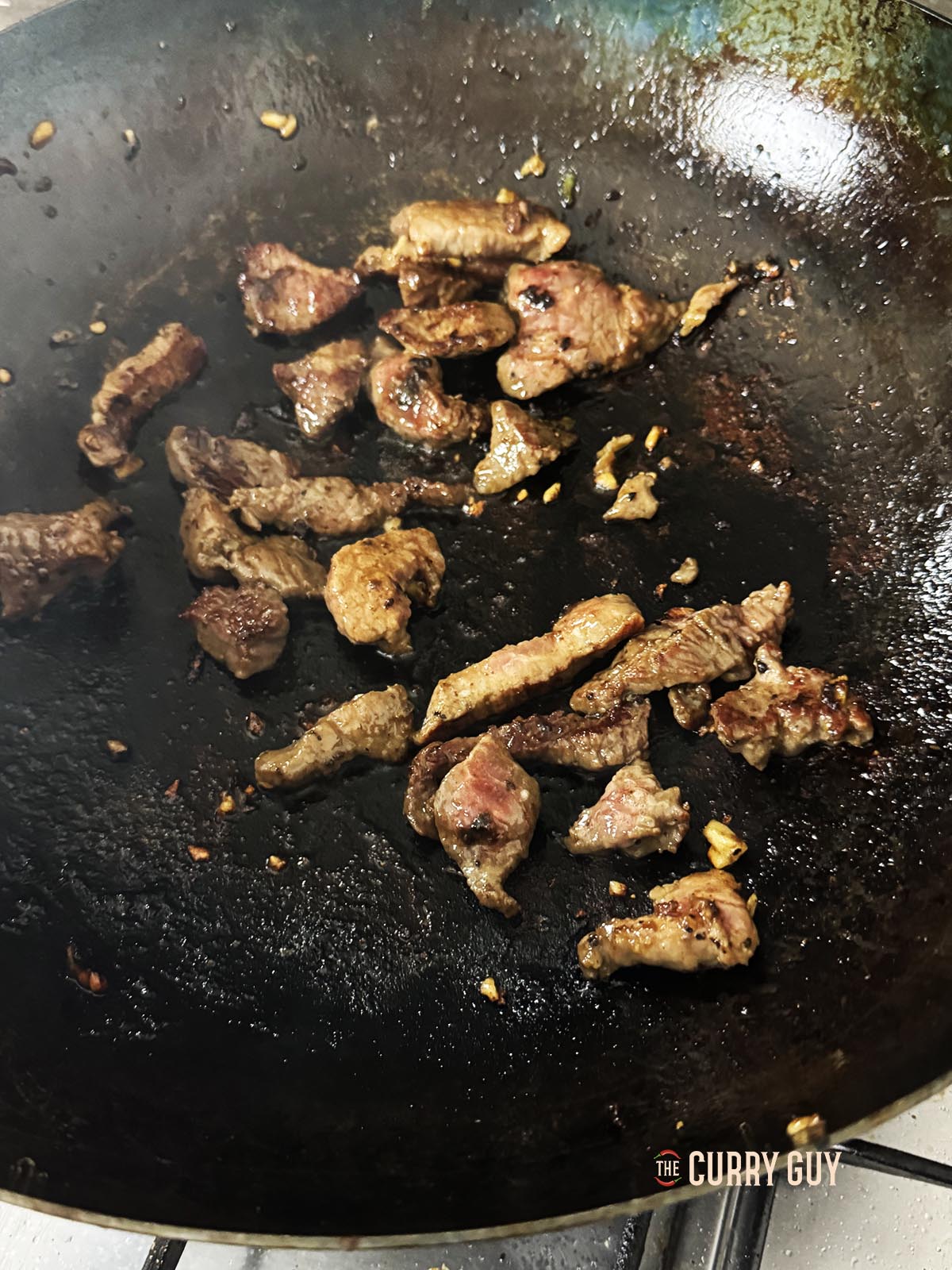 Frying the meat in a wok.