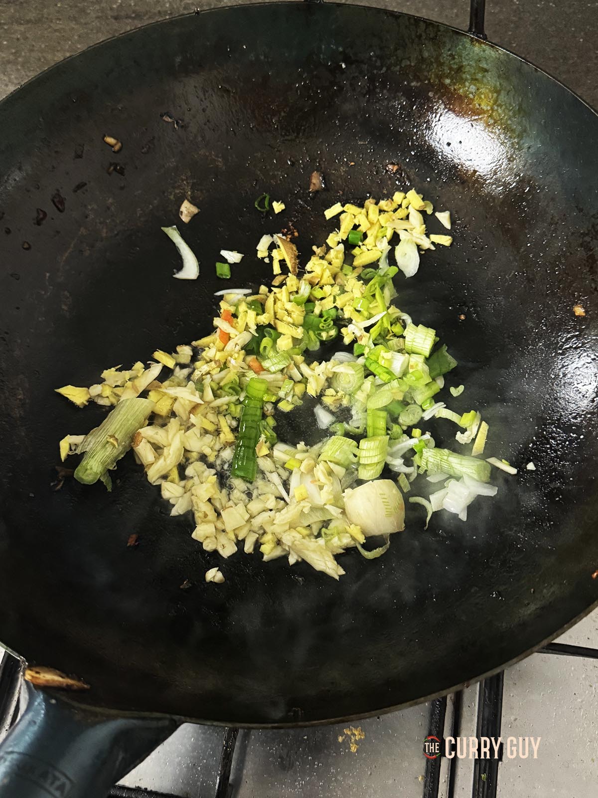 Frying the aromatic ingredients in the wok.
