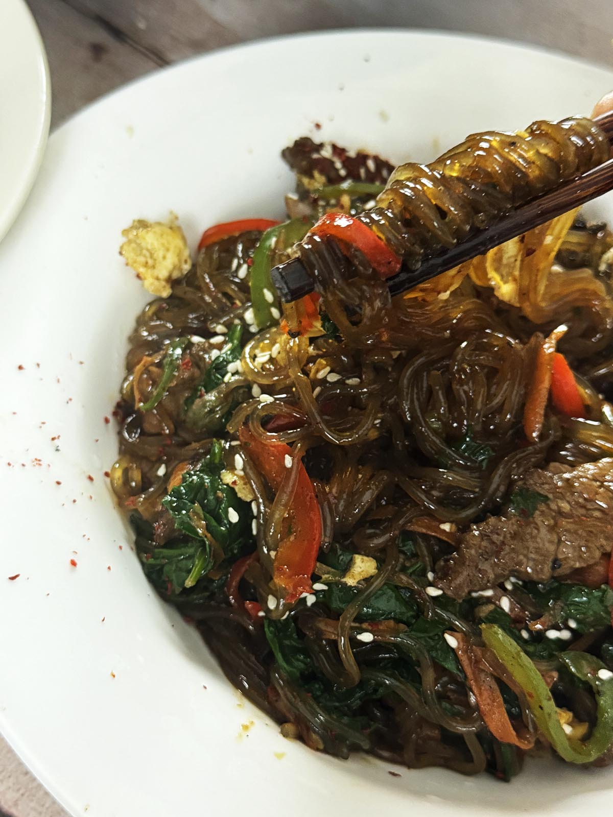Korean japchae eaten with chopsticks.