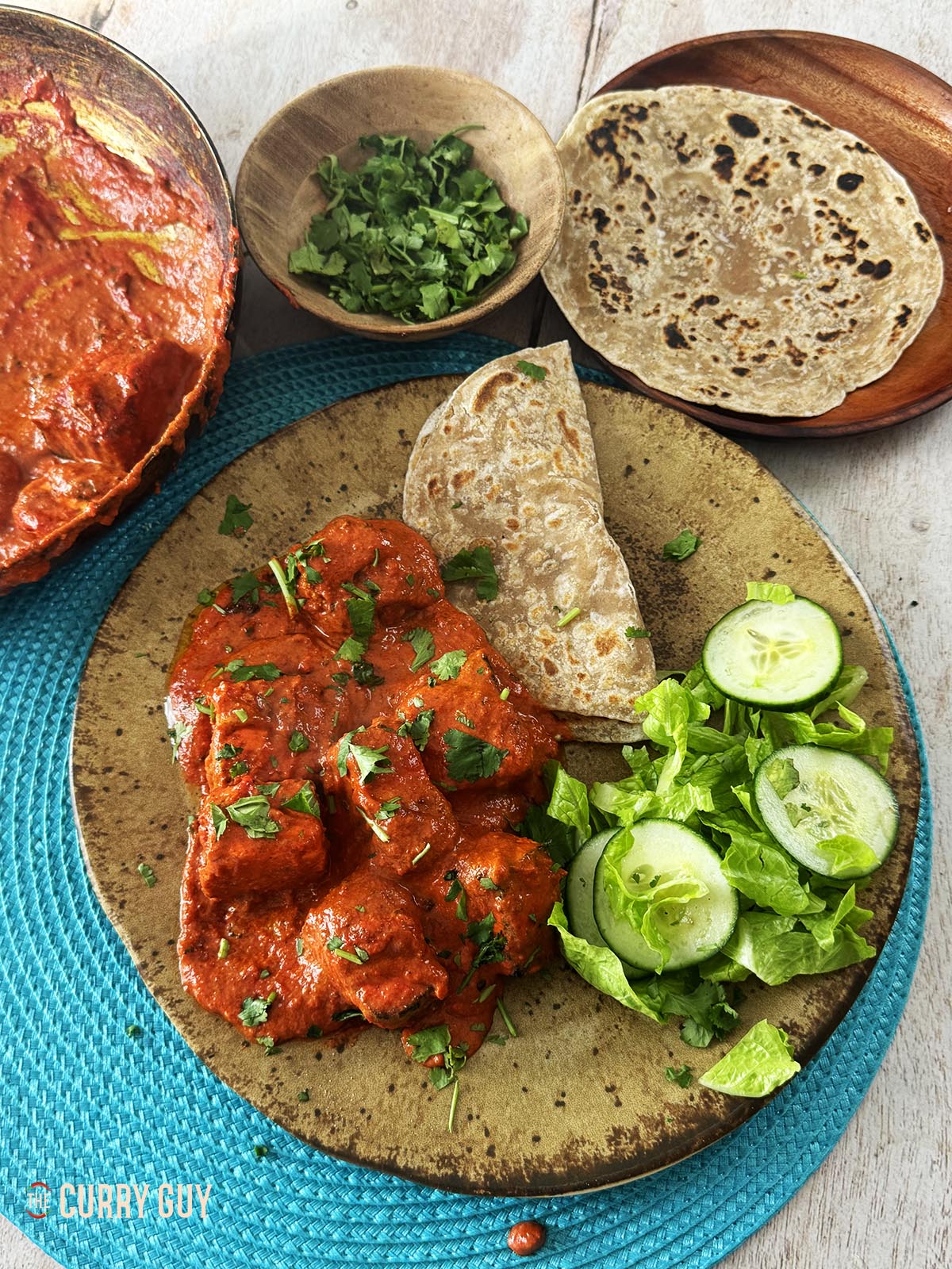 Paneer tikka masala on a serving plate with chapatti and salad.
