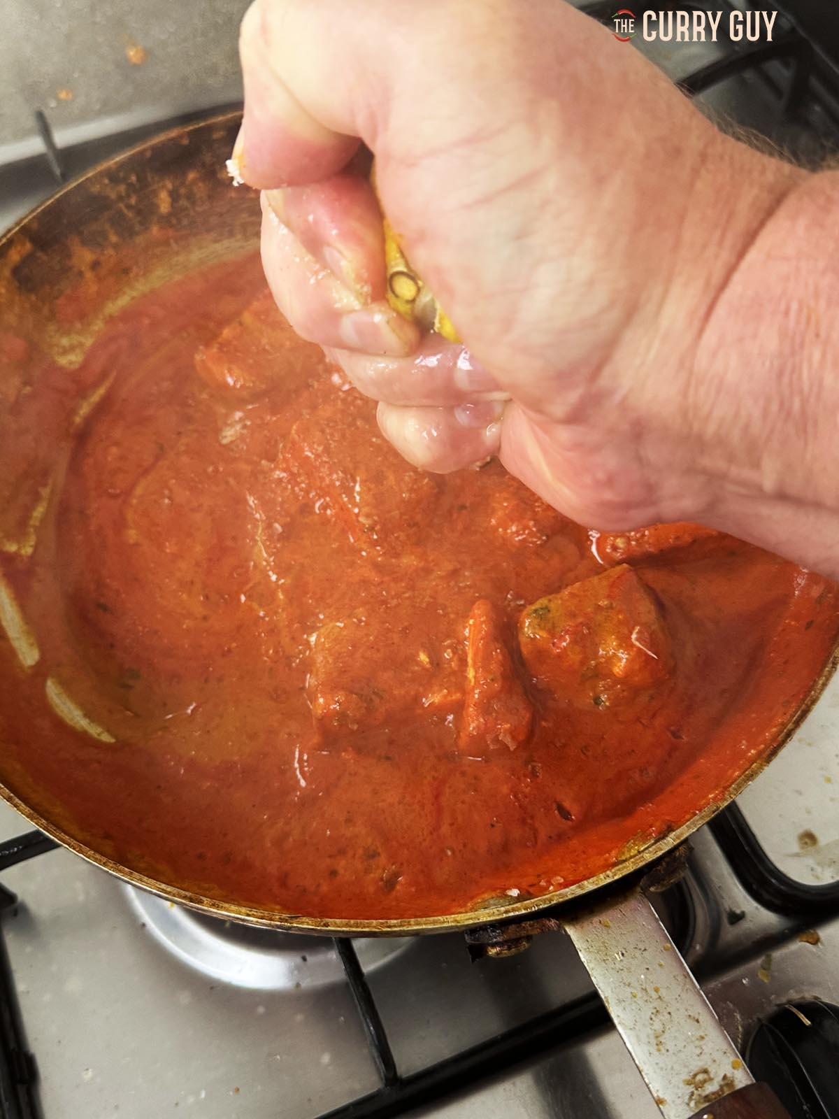 Stirring salt and lemon juice into the curry to taste.