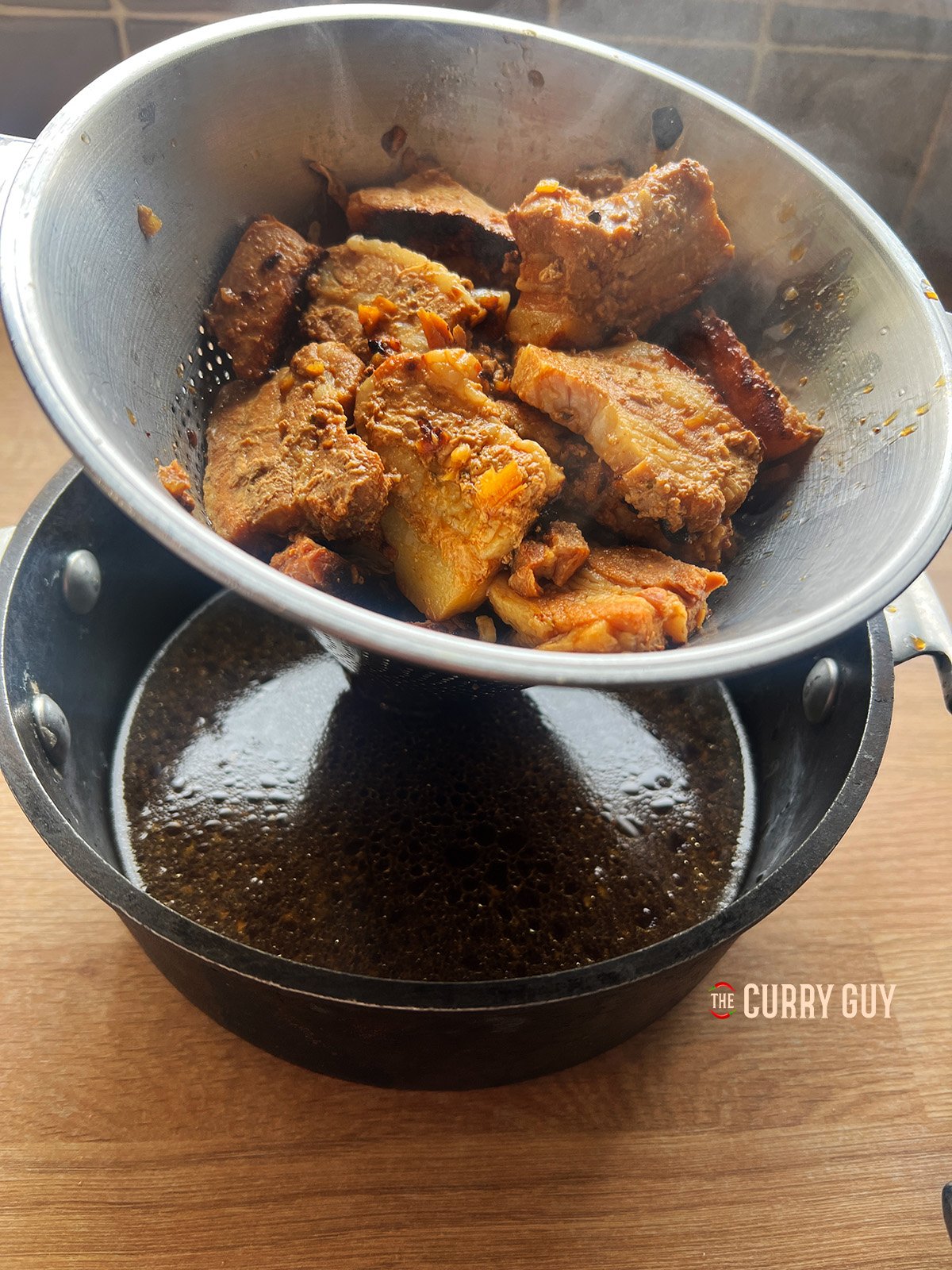 Draining the pork from the broth