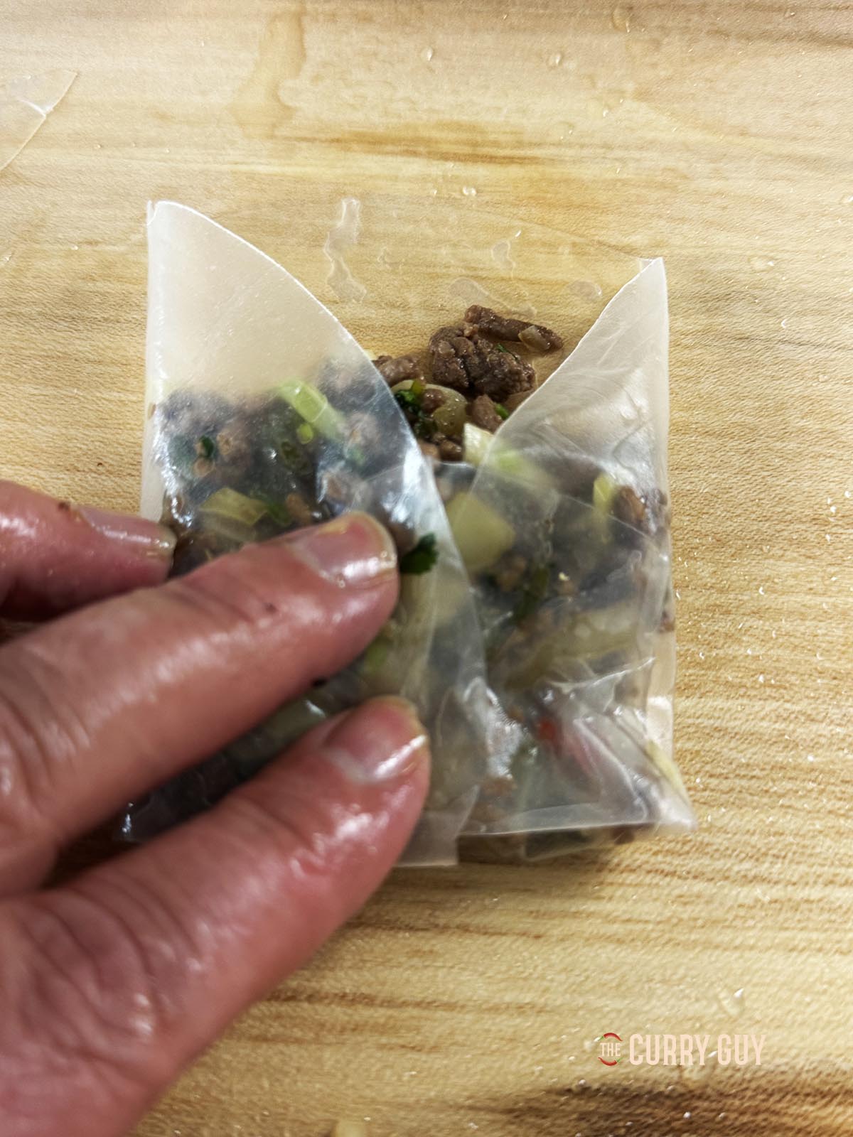 Folding the sides of the rice paper over the meat. 