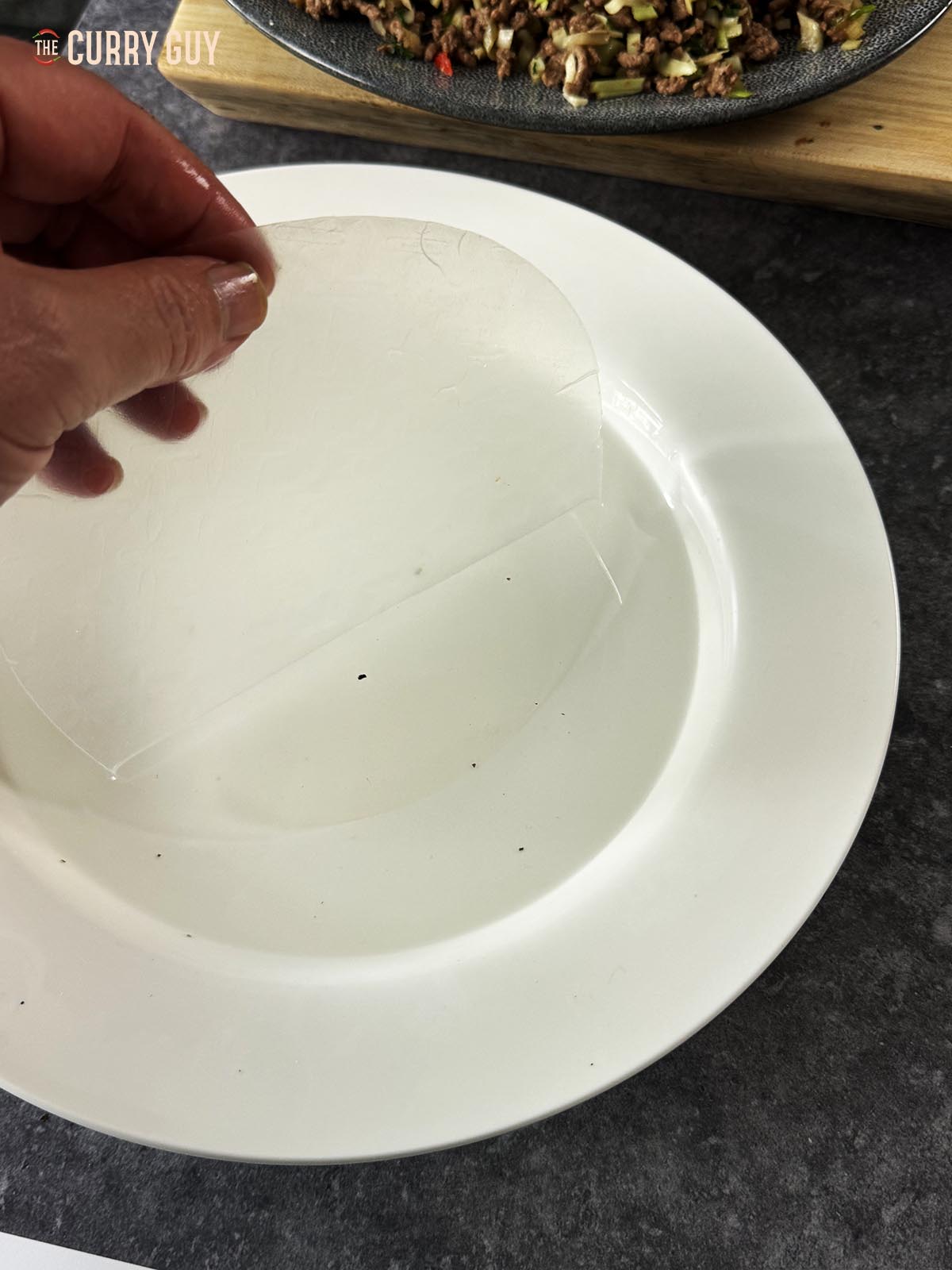 Dipping two sheets of rice paper in water.