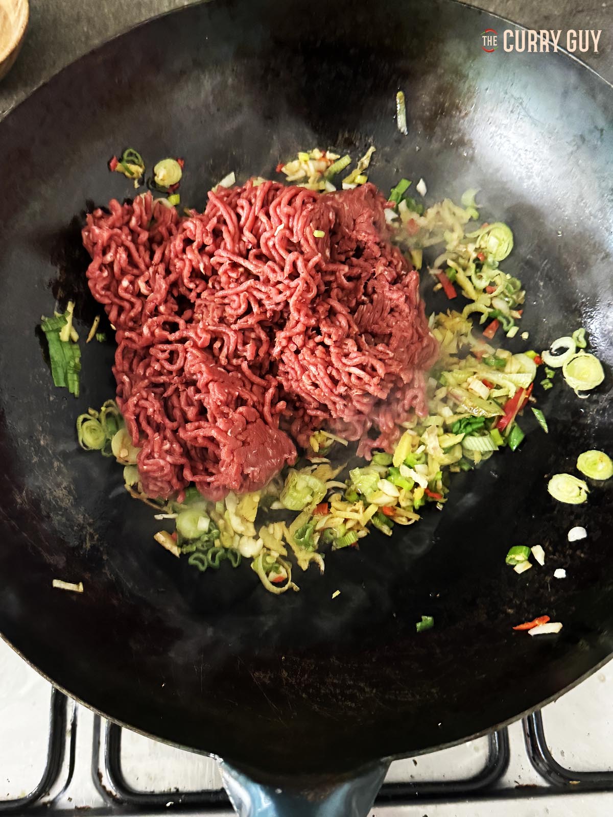 Adding the ground beef to the pan.