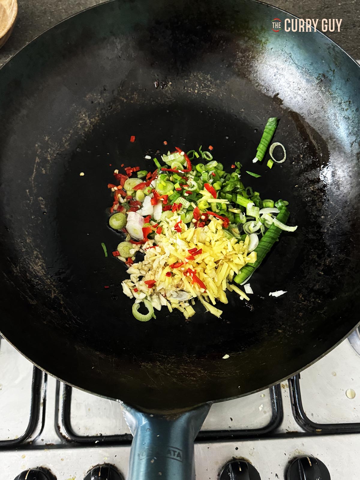 Frying the aromatic ingredients in a wok.